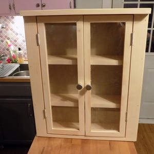 spice cabinet; curio cabinet; has extra wide top shelf