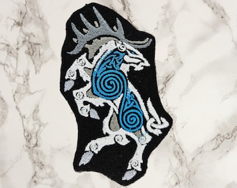 May include: Embroidered iron-on patch featuring a white stylized goat with blue Celtic knotwork design on a black background.