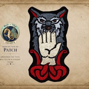 May include: Embroidered patch featuring a wolf biting a hand, with red accents and the text "IRON ON/SEW ON PATCH". The patch has a black border and a detailed design, suitable for clothing or accessories.