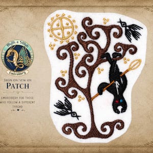 May include: An embroidered iron-on or sew-on patch featuring a brown stylized tree, a black figure hanging upside down from a branch while holding a gold staff, two black birds, and a gold sun. The patch includes text reading Myth a Stitch Embroidery.