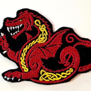 May include: Red embroidered dragon patch with yellow accents and a black background. The dragon is in a curled position with its wings spread out.