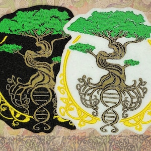 Könnte beinhalten: Zwei gestickte Bügelbilder mit einem grünen Baum mit braunen Ästen und Wurzeln, einer goldenen DNA-Helix und einem gelben verzierten Kreis. Die Patches sind auf schwarzem und weißem Stoff.