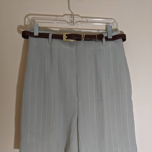 May include: Gray pinstripe shorts with a brown leather belt. The shorts have a high waist and a relaxed fit.