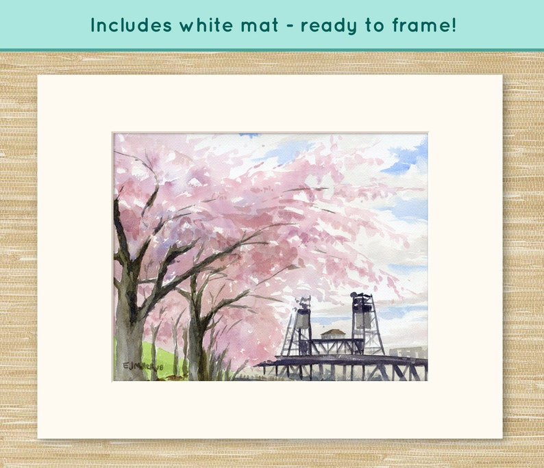 May include: Watercolor painting of a bridge with pink cherry blossoms in the foreground. The bridge is made of metal and has two towers. The painting is framed and includes a white mat.