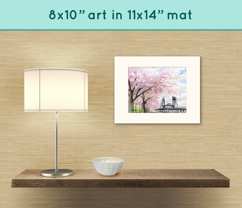 May include: A white matted print of a watercolor painting of a bridge with pink cherry blossoms. The print is 8x10 inches and is matted to 11x14 inches.