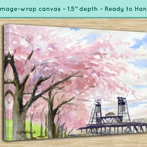 May include: Watercolor painting of a bridge with pink cherry blossoms in the foreground. The bridge is made of metal and has a wooden deck. The cherry blossoms are in full bloom and are a vibrant pink color. The painting is on a canvas and is ready to hang.