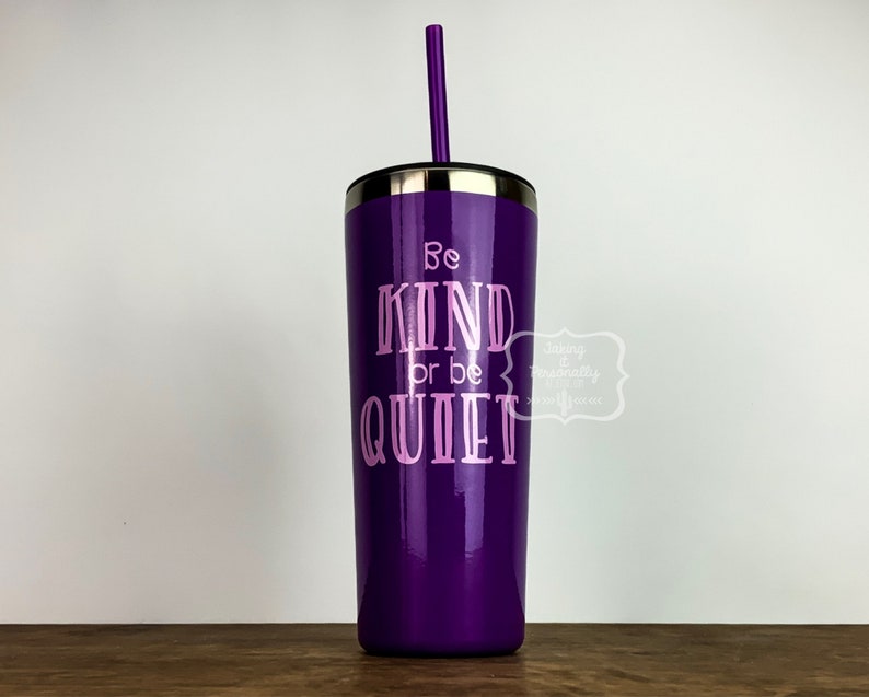 Puede incluir: Un vaso de acero inoxidable morado con un dise&ntilde;o de vinilo rosa que dice "Be Kind or Be Quiet". El vaso tiene una tapa y una pajita.
