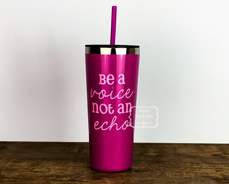 Puede incluir: Un vaso de acero inoxidable rosa con una pajita rosa. El vaso tiene el texto "Be a voice not an echo" impreso en &eacute;l.