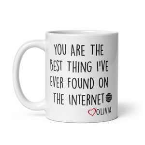 May include: White ceramic mug with black text that reads "You are the best thing I've ever found on the internet" with a globe icon and a red heart with the name "Olivia" below the text.