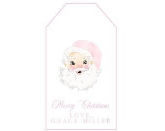 May include: A rectangular gift tag with a pink border featuring a watercolor illustration of Santa Claus wearing a pink hat. Below the illustration, the text reads Merry Christmas, LOVE, GRACE MILLER in a light pink, elegant script and block font.