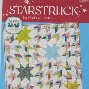 May include: A quilt pattern titled "STARSTRUCK" by Dodi Lee Poulsen. The design features a repeating pattern of star shapes in various colors, including green, blue, pink, and yellow, on a white background. The pattern includes the text "Two Sisters at Squirrel Hollow".
