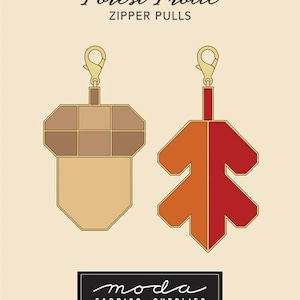 May include: Two zipper pulls in the shape of an acorn and a leaf. The acorn is tan and brown, and the leaf is orange and red. The text "ROBIN PICKENS Forest Frolic ZIPPER PULLS" is at the top.
