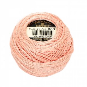 May include: A ball of peach-colored DMC Perlé 8 cotton thread. The label reads "Perlé 8 Col. 353" and "Made in France". The thread is tightly wound, showing the texture of the cotton. Ideal for embroidery and other needlecraft projects.