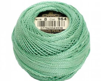 May include: A ball of mint green DMC Perle 8 cotton thread, Col. 954, with a product label visible in the center. The thread is tightly wound, creating a textured surface. Ideal for embroidery and other needlecraft projects.