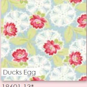May include: A fabric swatch with a floral pattern. The design features red flowers with green leaves and white lace-like shapes on a light blue background. The text "Ducks Egg" is visible.