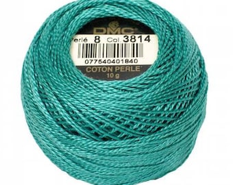 May include: A ball of teal DMC Perle cotton thread, size 8, with a label showing the color code 3814 and a weight of 10 g. The thread is tightly wound, and the label includes a barcode and the words "COTON PERLE".