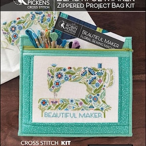 May include: A teal zippered project bag kit with a cross-stitched sewing machine design. The design features blue, green, and white floral elements, with the words "BEAUTIFUL MAKER" below. The kit includes thread and instructions.