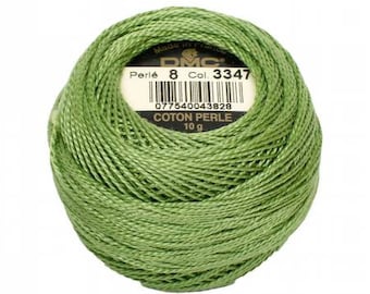 May include: A ball of green DMC Perlé cotton thread, 10 g, with a label showing the product details. The thread is tightly wound, and the label includes the product name, color number 3347, and a barcode.