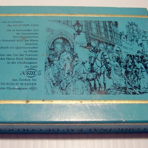 Puede incluir: Una caja azul y dorada con una ilustraci&oacute;n en blanco y negro de una escena hist&oacute;rica. La caja tiene el texto "4711 ORIGINAL EAU DE COLOGNE" en la parte inferior y el texto "ECHT K&Ouml;LNISCH WASSER aus der Glockengasse" en la parte delantera. La ilustraci&oacute;n muestra un grupo de personas en una escena de calle con un caballo y un carruaje.