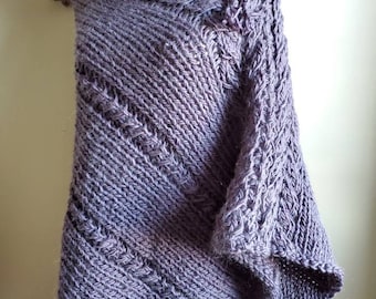 May include: A gray knitted shawl with a button closure. The shawl is made of a soft, textured yarn and has a loose, drapey fit.