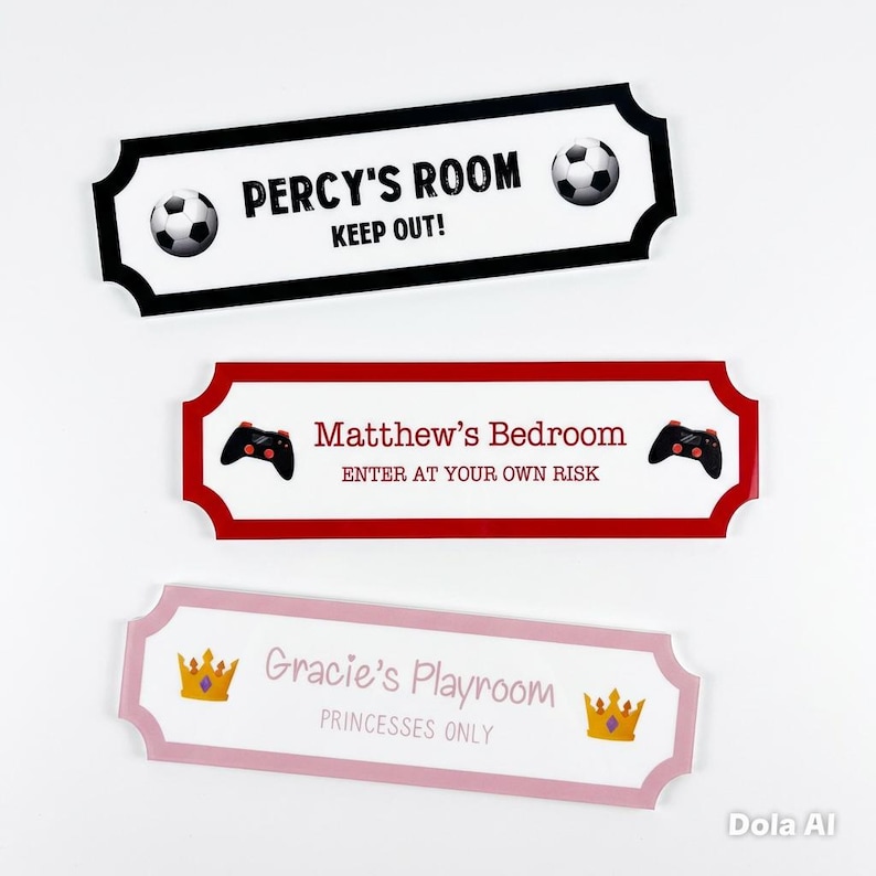 Puede incluir: Tres letreros decorativos para habitaciones con bordes negros, rojos y rosas. El letrero negro dice "PERCY'S ROOM KEEP OUT!" con balones de f&uacute;tbol. El letrero rojo dice "Matthew's Bedroom ENTER AT YOUR OWN RISK" con mandos de juego. El letrero rosa dice "Gracie's Playroom PRINCESSES ONLY" con coronas.