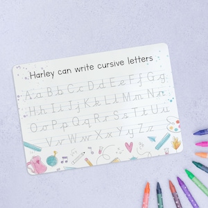 May include: A white dry-erase board with the text "Harley can write cursive letters" at the top. The board has dotted lines for practicing cursive letters A through Z.