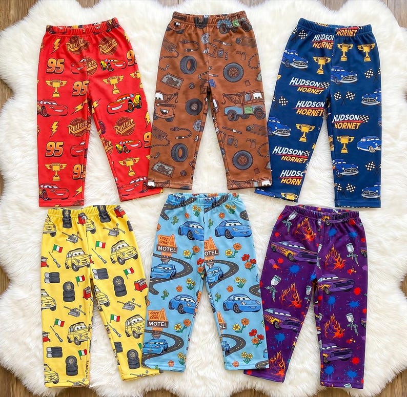 Puede incluir: Seis pantalones con varios estampados de personajes de la pel&iacute;cula Cars. Los pantalones son rojos, marrones, azules, amarillos, azul claro y morados, cada uno con cintura el&aacute;stica y un patr&oacute;n repetitivo de veh&iacute;culos, neum&aacute;ticos y trofeos.