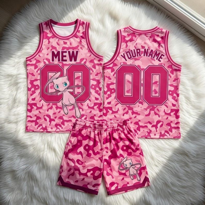 May include: Two pink camouflage basketball jerseys and matching shorts. One jersey features the text MEW and the number 00, the other features YOUR NAME and 00. Both jerseys and the shorts display a pink Mew character graphic.