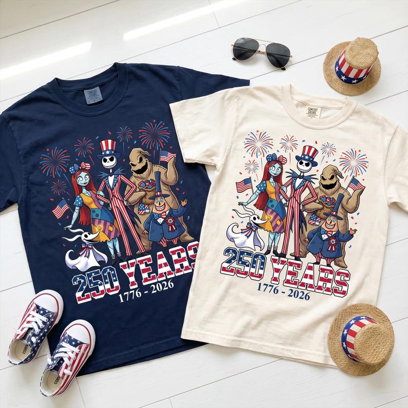 Puede incluir: Dos camisetas, una azul marino y otra crema, con un gr&aacute;fico de personajes de Pesadilla antes de Navidad vestidos con ropa patri&oacute;tica, fuegos artificiales y el texto 250 YEARS 1776-2026. Incluye dos pares de zapatillas con estampado de bandera.