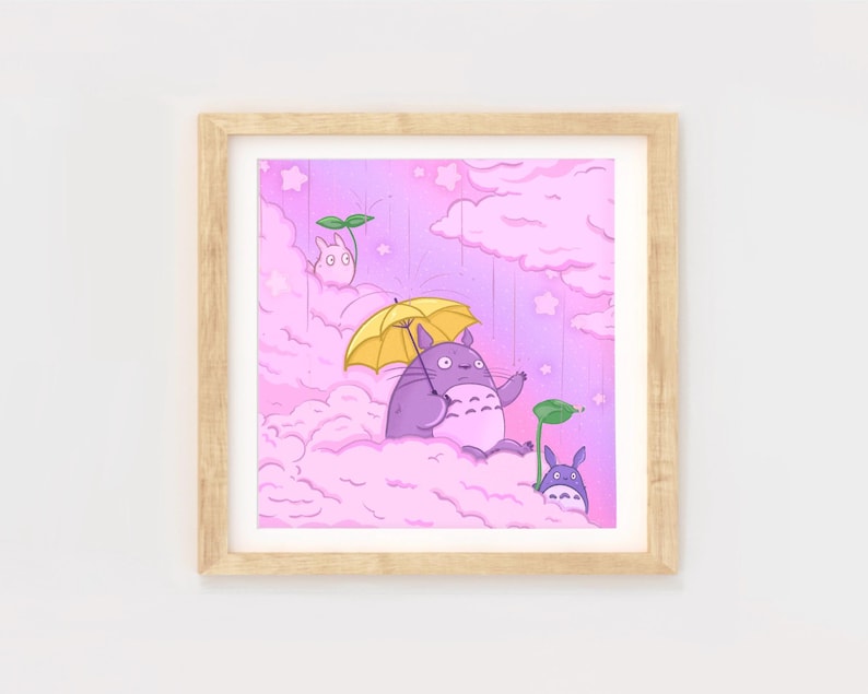 May include: A framed illustration of a purple Totoro character holding a yellow umbrella, standing on a pink cloud with two other smaller Totoro characters. The background is a pink sky with white stars.