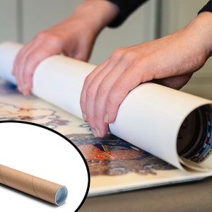 May include: A person is rolling up a large print or poster into a white cardboard tube. The tube is being rolled up from the bottom, and the person is using their hands to guide the print into the tube. The print is colorful and has a detailed design. A brown cardboard mailing tube is shown in the foreground.