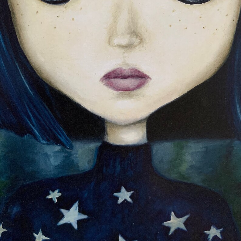 May include: A close-up of a woman's face with blue hair and a dark blue turtleneck sweater with white stars. The woman has a sad expression and her lips are painted a dark pink.