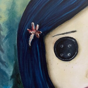 May include: A close-up of a painting of a girl with blue hair and a button eye. She has a small pink flower in her hair.
