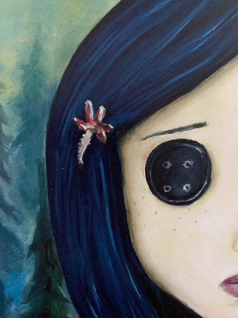 May include: A close-up of a painting of a girl with blue hair and a button eye. She has a small pink flower in her hair.
