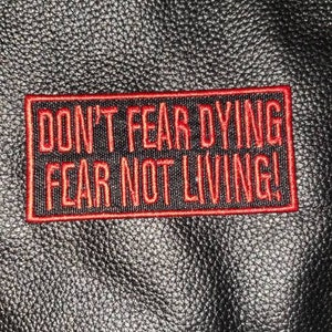 May include: Black leather jacket with a red embroidered patch that reads "Don't Fear Dying Fear Not Living!"