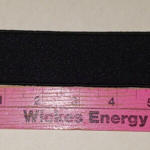 May include: A rectangular black patch with a textured surface, approximately 5 inches long, is displayed next to a pink ruler. The ruler has black markings and the text "Wickes Energy Stick".