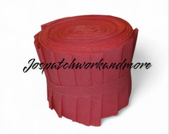 May include: A roll of red fabric with a pleated edge, tightly wound. The fabric is a solid, deep red color. The text "Jospatchworkandmore" is written in cursive on the fabric.