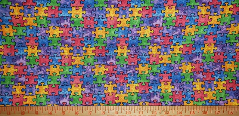 K&ouml;nnte beinhalten: Bunter Stoff mit einem sich wiederholenden Muster aus Puzzleteilen. Die Teile sind in verschiedenen Farben gehalten, darunter Rot, Gelb, Gr&uuml;n, Blau und Lila, mit schwarzen Umrissen. Geeignet zum Quilten oder Basteln.