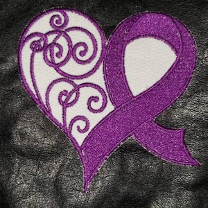 May include: Embroidered patch featuring a purple awareness ribbon and a heart design. The heart is white with purple swirling embroidery. The patch is on a black textured background.