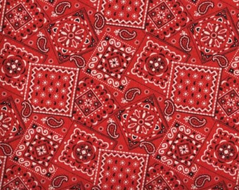 May include: Red fabric with a repeating pattern of white and black bandana designs. The fabric is measured with a ruler in inches.
