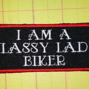 May include: Black embroidered patch with red stitching. The patch reads "I am a Classy Lady Biker".