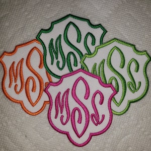 May include: Four embroidered patches in the shape of a shield with the letters "MSC" in a script font. The patches are in the colors orange, green, lime green, and pink.