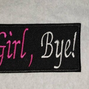 May include: Black rectangular patch with the phrase "Girl, Bye!" embroidered in pink and white. The patch is a rectangle with rounded corners, and the text is in a cursive font.