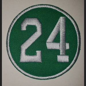 May include: A green and white circular patch with the number 24 embroidered in white on a green background.