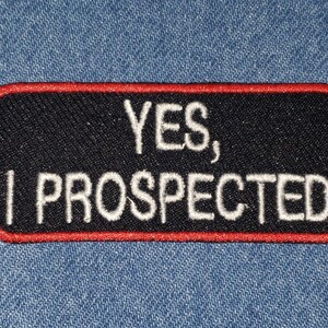 May include: Black embroidered patch with red stitching. The patch reads "YES, I PROSPECTED" in white text.