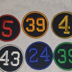 May include: Six round black fabric patches with white, red, yellow, blue, and green numbers. The numbers are 5, 39, 4, 43, 24, and 39.