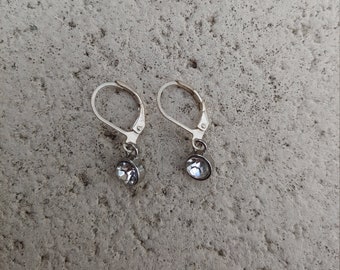 May include: A pair of silver dangle earrings with clear crystal stones.