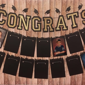 May include: A graduation-themed banner with the word "CONGRATS" in gold glitter letters. The banner includes black photo holders with grade labels and student photos, all against a wood-grain background.