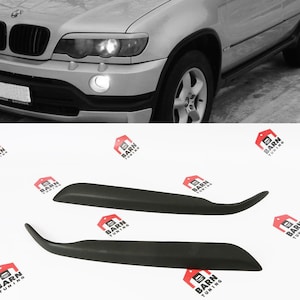 Könnte beinhalten: Zwei schwarze Kunststoffverkleidungen für ein Auto. Die Verkleidungen sind gebogen und haben eine glatte Oberfläche.