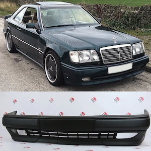 Peut inclure: Coup&eacute; vert fonc&eacute; avec une calandre argent&eacute;e et des roues noires. La voiture a un design &eacute;l&eacute;gant et est gar&eacute;e sur une route pav&eacute;e. En dessous, un pare-chocs noir avec une ouverture rectangulaire et des lattes horizontales.